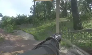 Postać w Kingdom Come: Deliverance celuje z łuku przez las. Widoczny jest kompas i pasek zdrowia.
