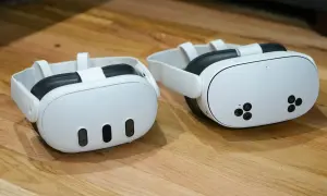 Dwa białe gogle VR Meta Quest 3 na drewnianym blacie.