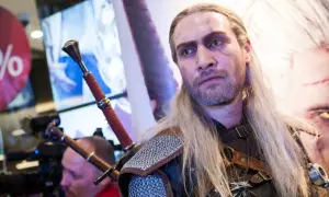 Geralt z Rivii, wiedźmin z blizną na twarzy, z dwoma mieczami za plecami.