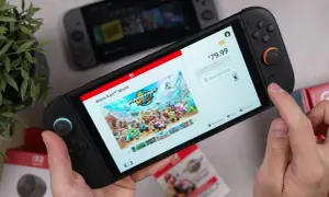 Ręce trzymają konsolę Nintendo Switch, na ekranie której wyświetla się gra Mario Kart World. To świetny przykład gry ruchowej na Nintendo Switch.