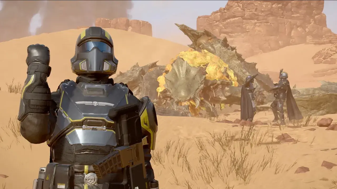 Helldivers 2 crossplay: żołnierze w pancerzach walczą z potworem na pustyni.